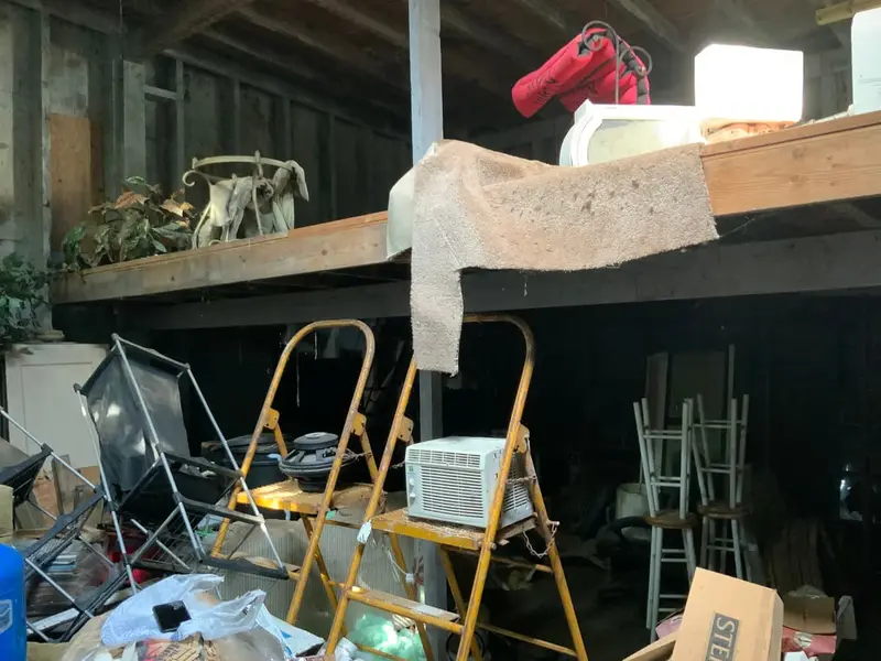 Garage loft crammed with ladders and old gear, Bay Shore, NY