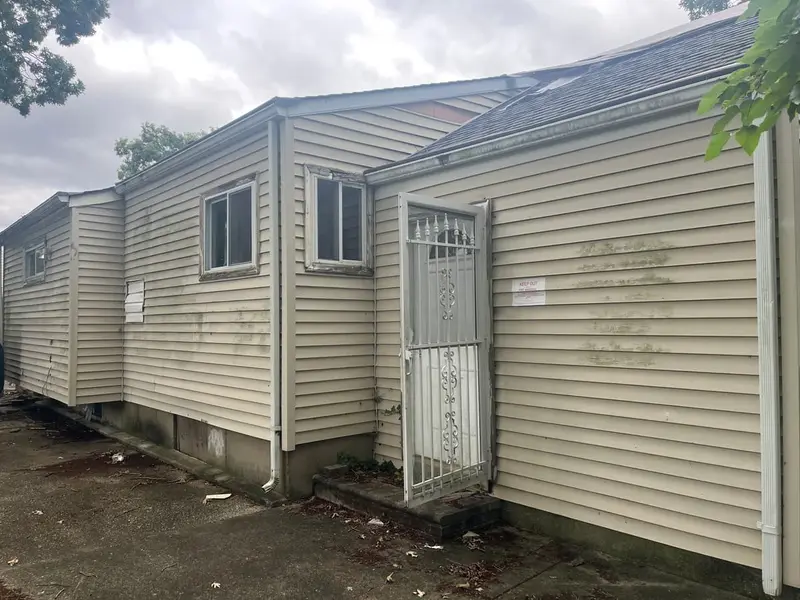 Side of a vacant ranch with a security door, Bay Shore, NY